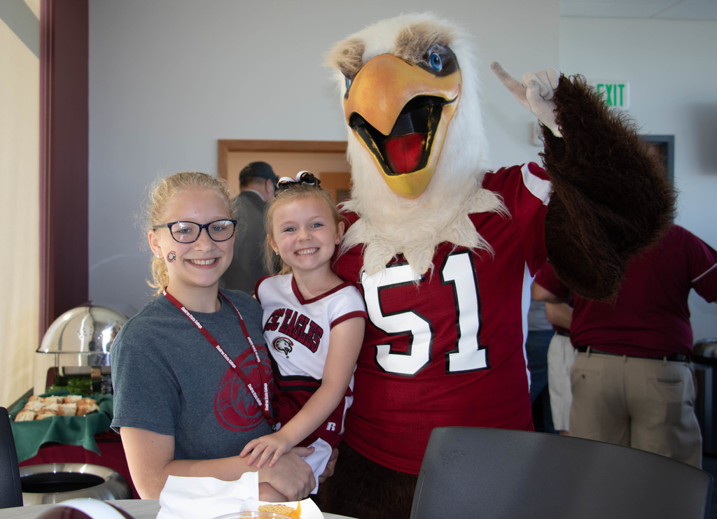 Fans pose with Elmo in the Lewellen Hospitality Room