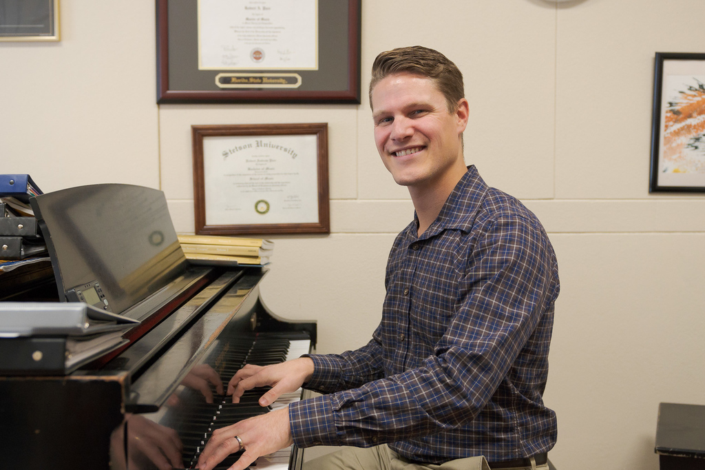 Accompanist Bobby Pace smiles while playing the piano in his office.