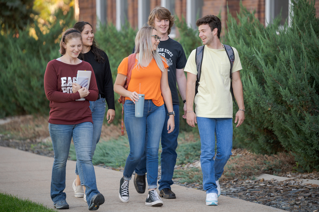 Five CSC students walk by the front of Old Admin.