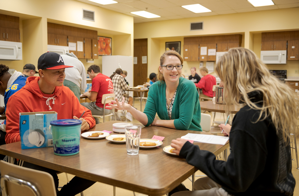 Three CSC students sit at a table studying the dinning halls food.