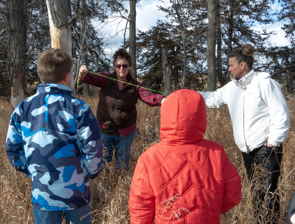 Four people measuring in a forest