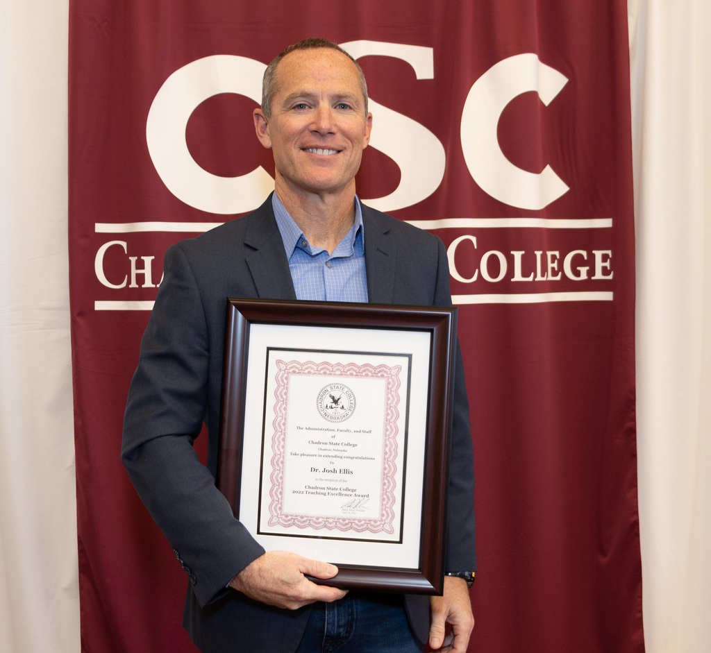 Professor Josh Ellis poses with award