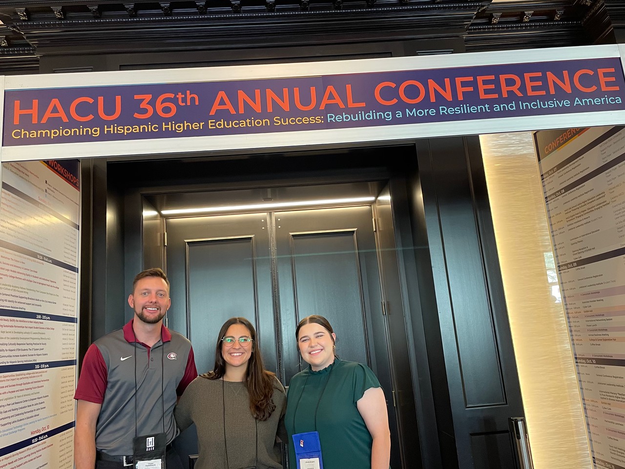 Three people posing at a conference