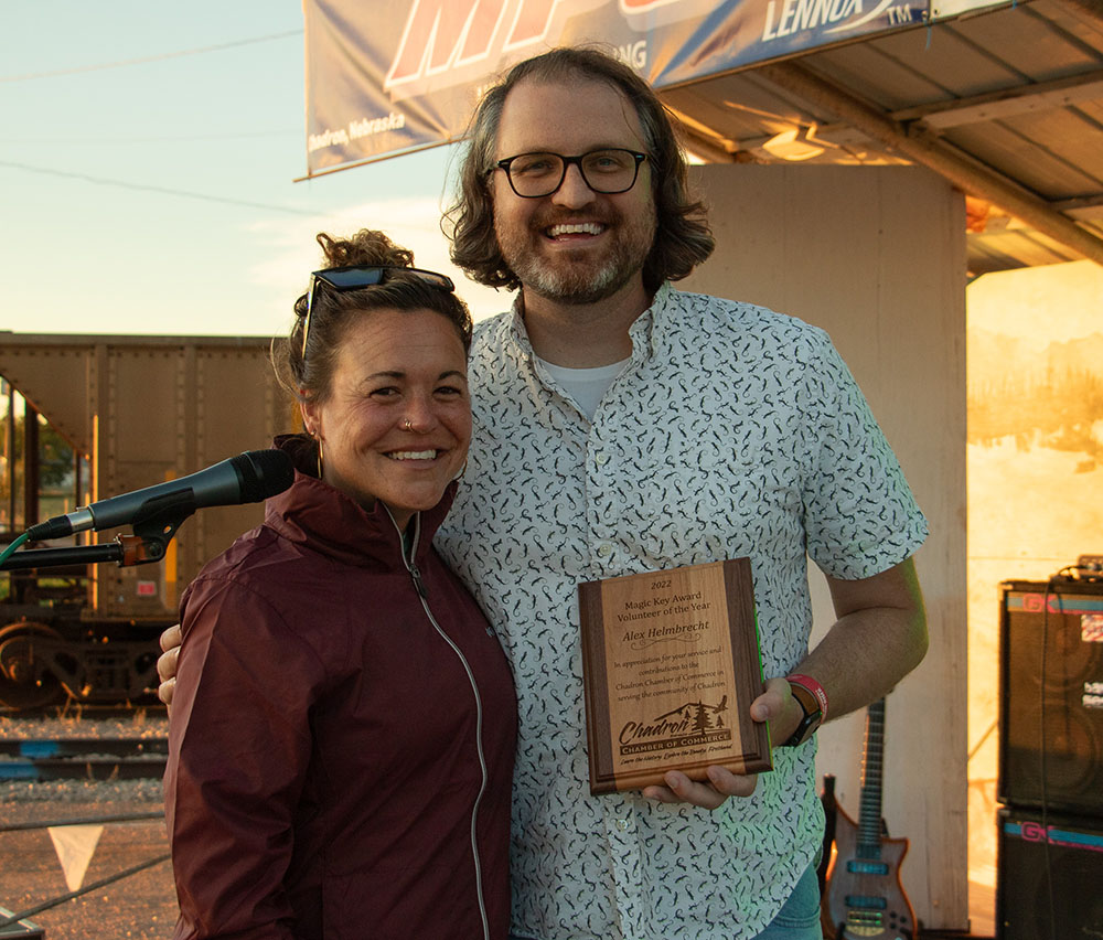 Two people posing with an award