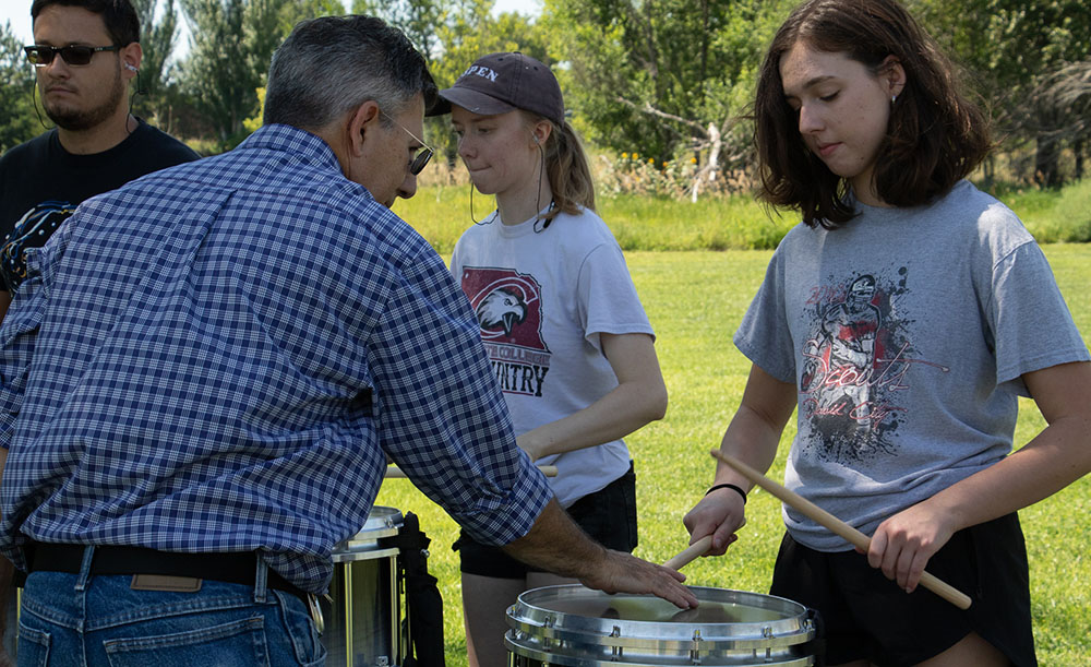 Professor showing a student how to play an instrument