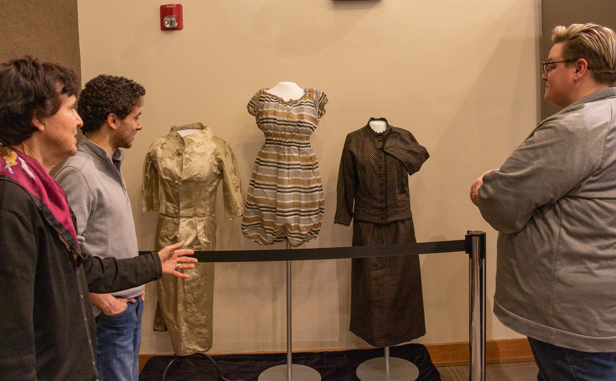 Three people looking at a museum display