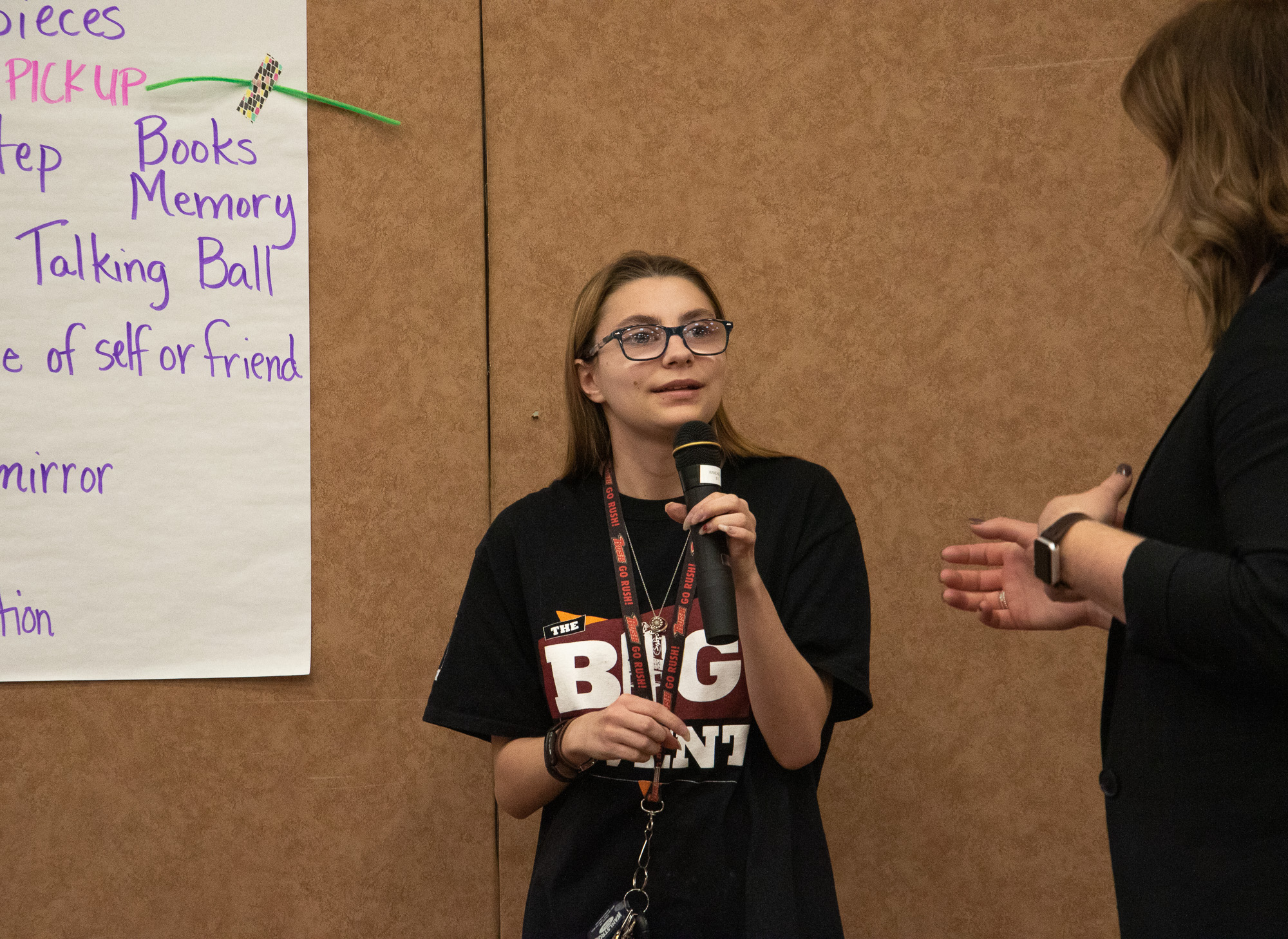 Student speaking by a wall poster