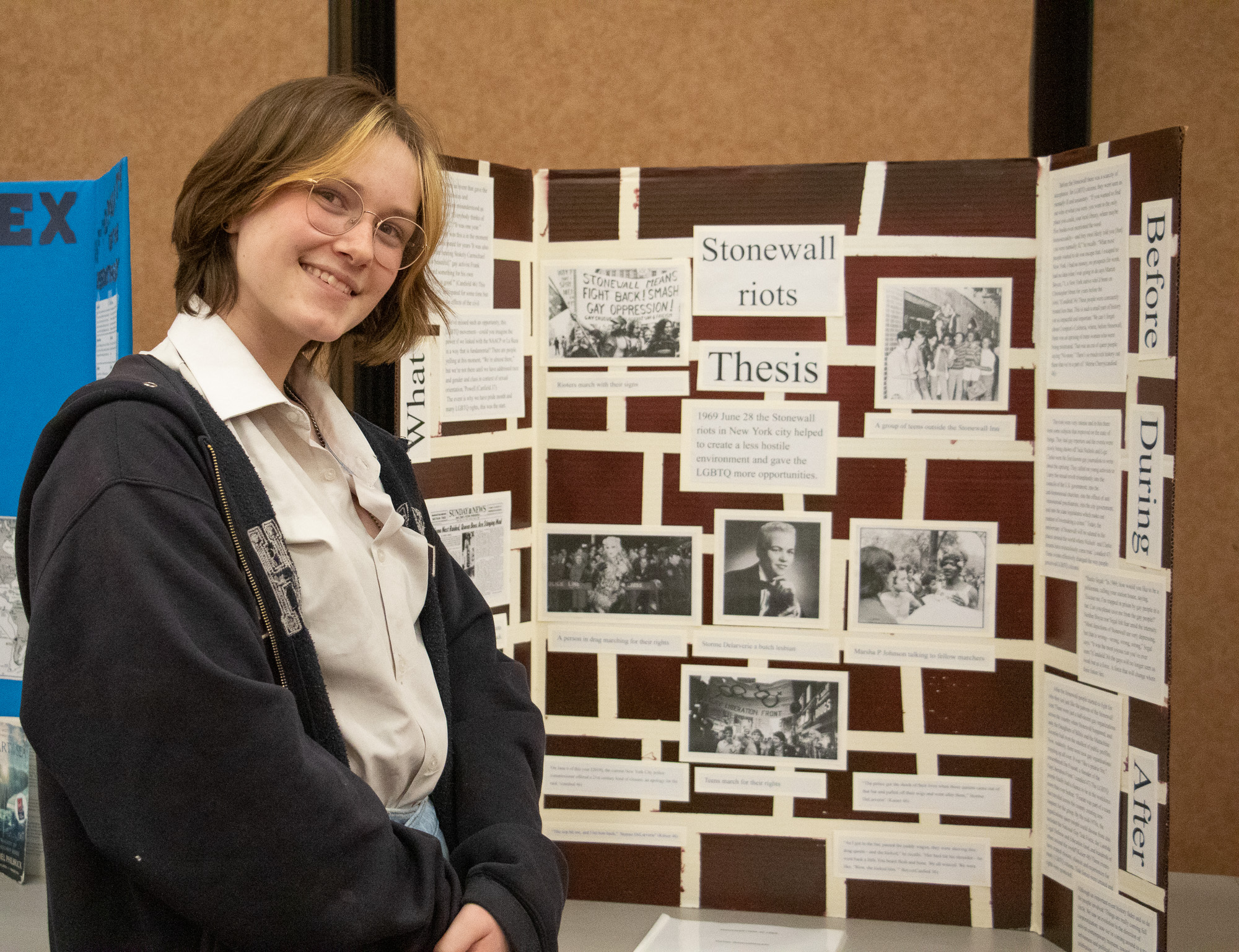 A girl standing by a poster display