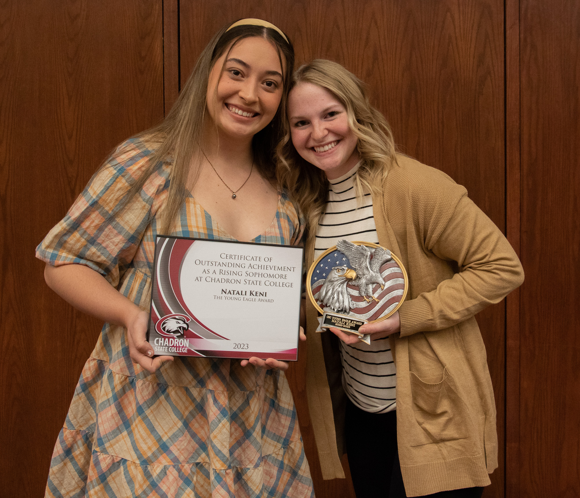 Two women posing with awards