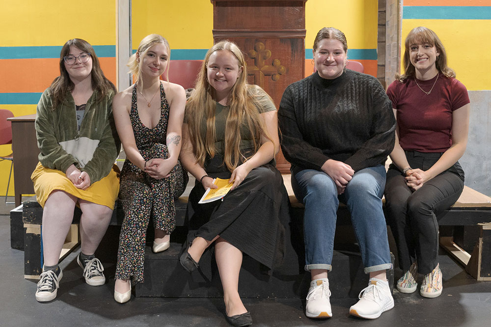 Cast posing on a stage