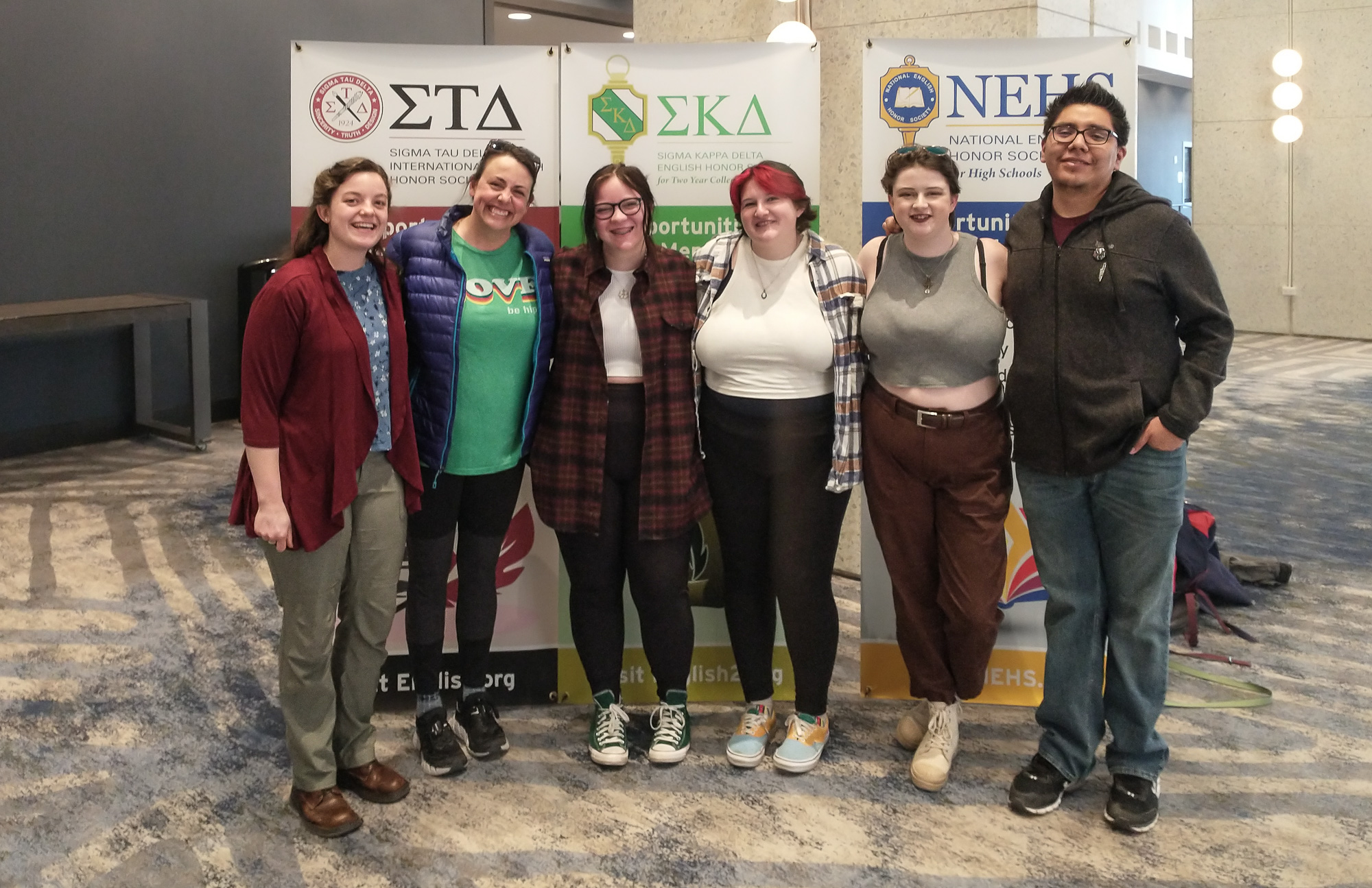 Six adults posing at a convention