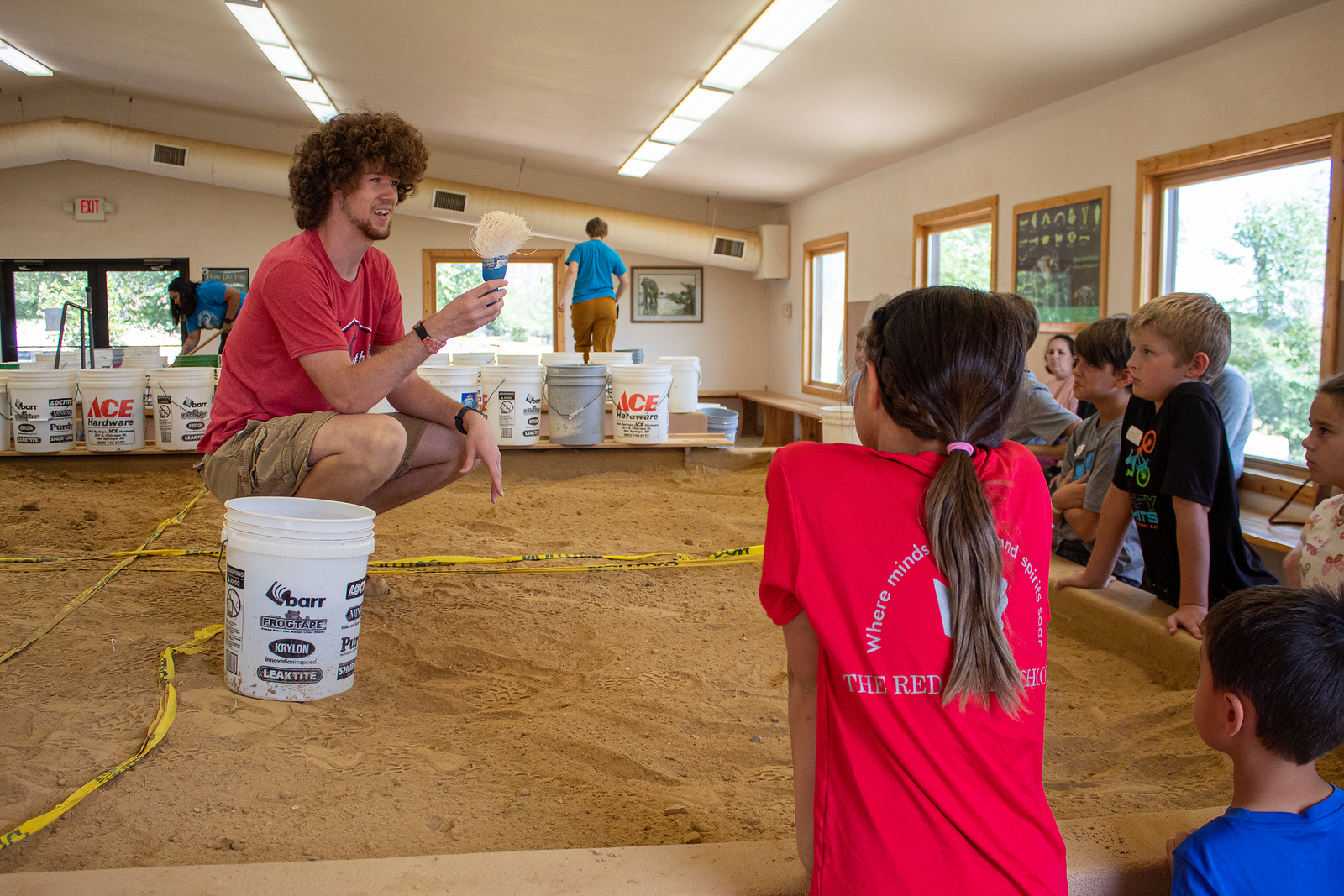 Student teaching children at a fossil dig