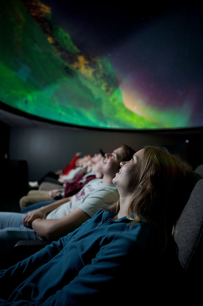 College students seated in a planetarium