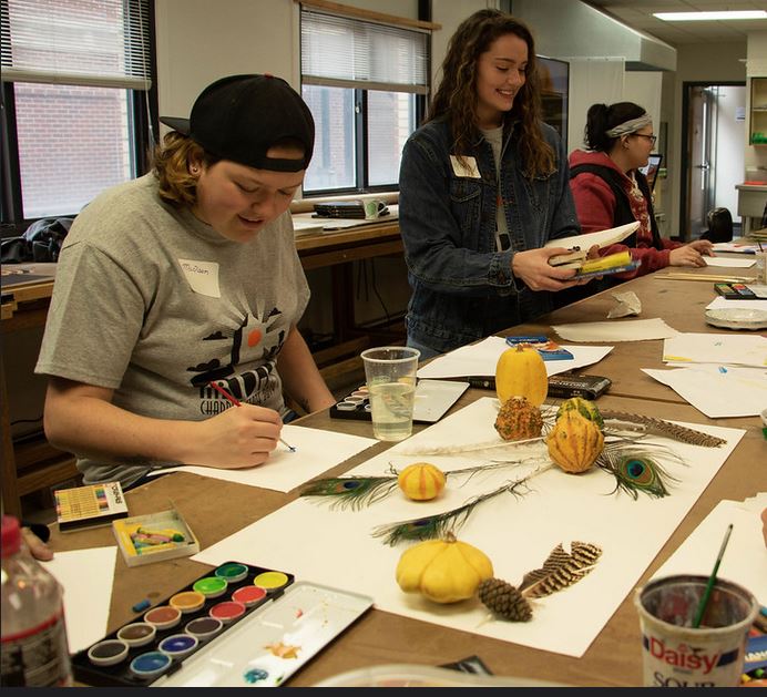 Students painting still life objects