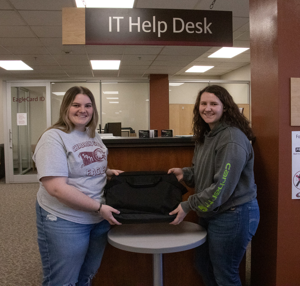 Two women holding a laptop