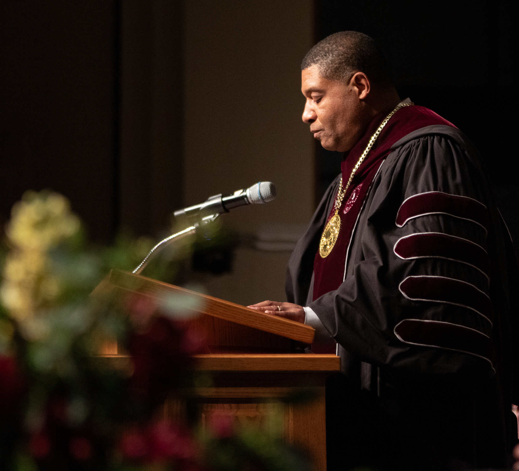 Speaker at a podium wearing a medallion