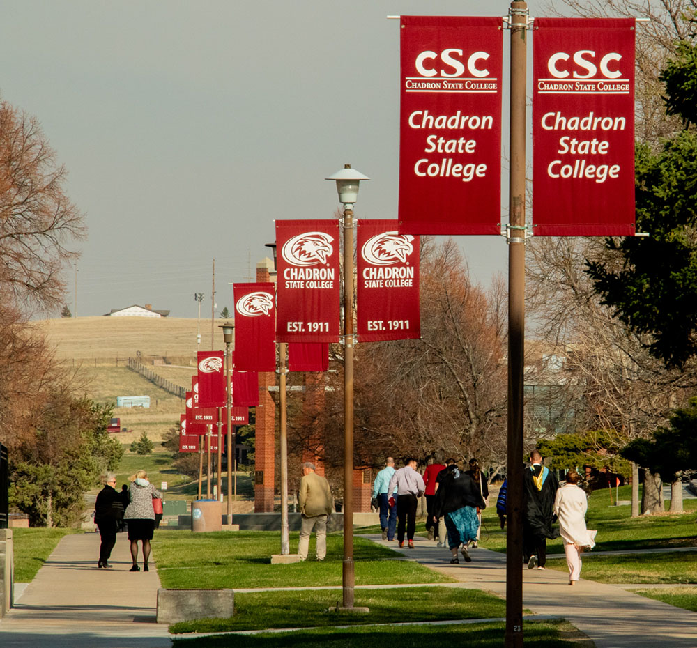 People on a sidewalk under banners