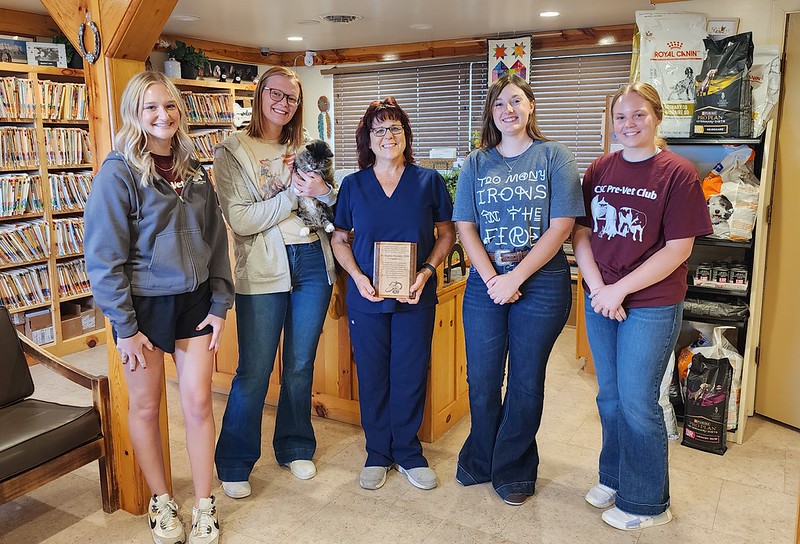 Five adults standing inside a vet office