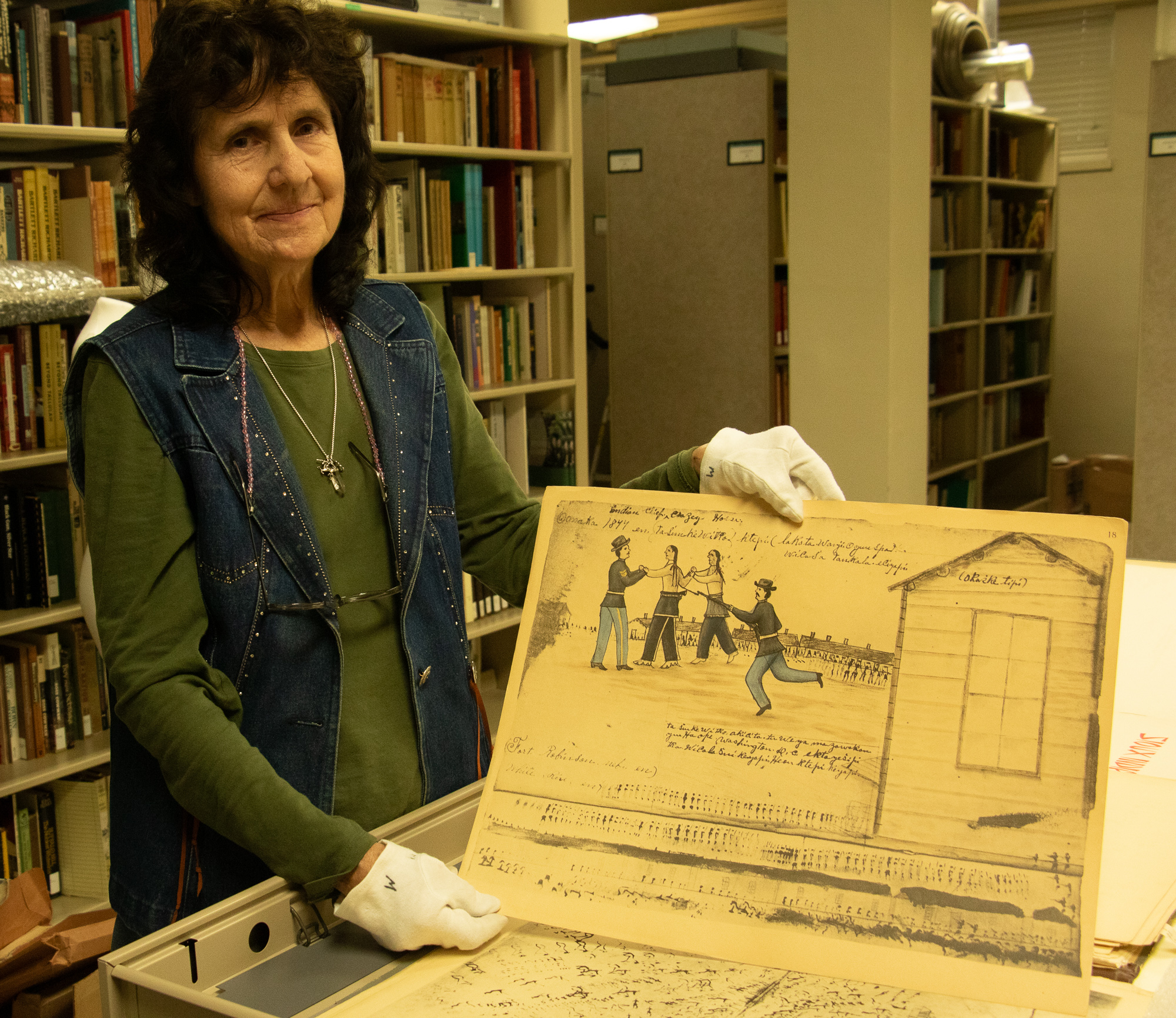 Woman posing in an archive with art