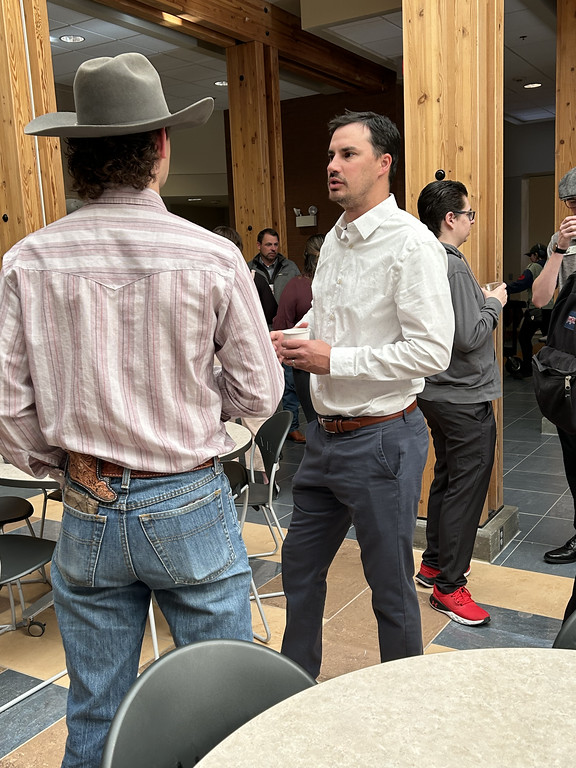 Two men standing and talking inside