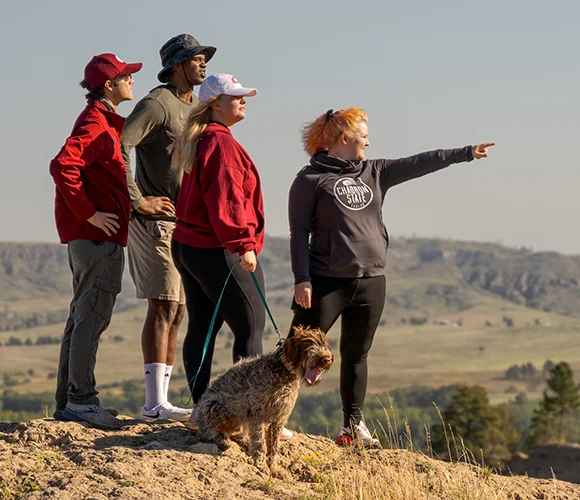 Group of hikers with a dog on a butte