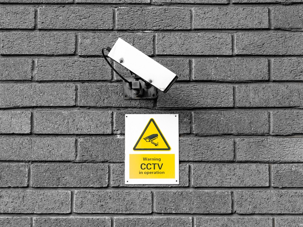 Security camera with a sign under saying CCTV in operation