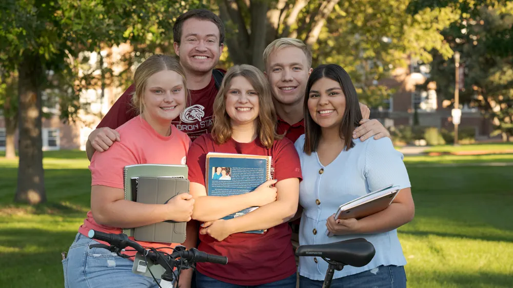 Five students posing for a photo on the Dean's Green