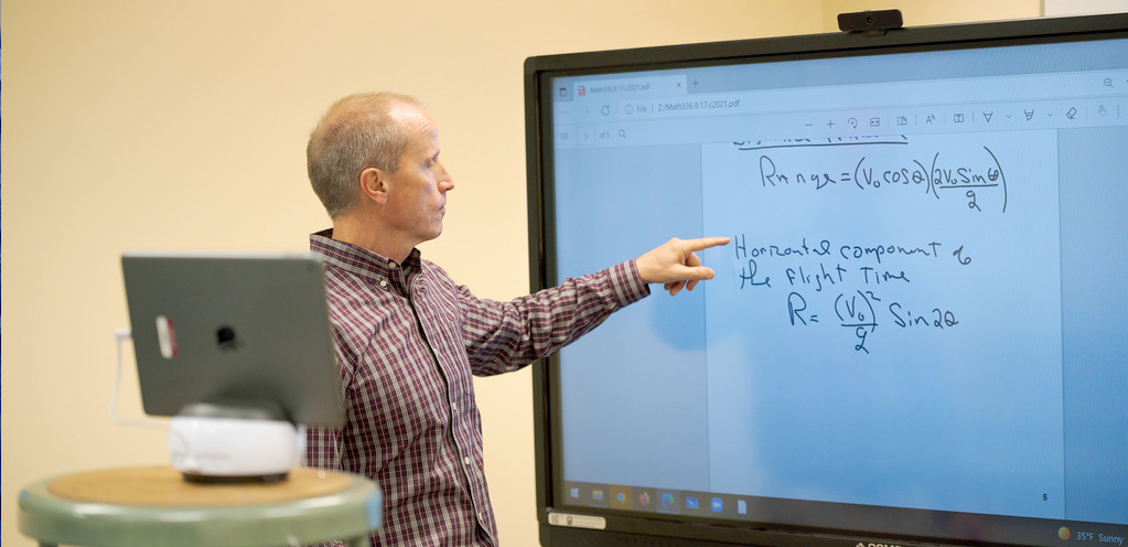 Dr. Vogl recording a video demonstration in front of a digital whiteboard.